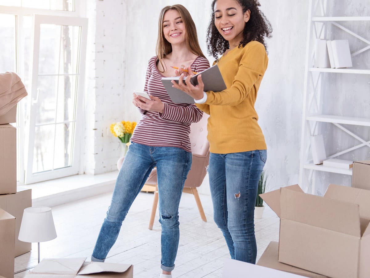 image of two girls unpacking moving boxes in a new apartment