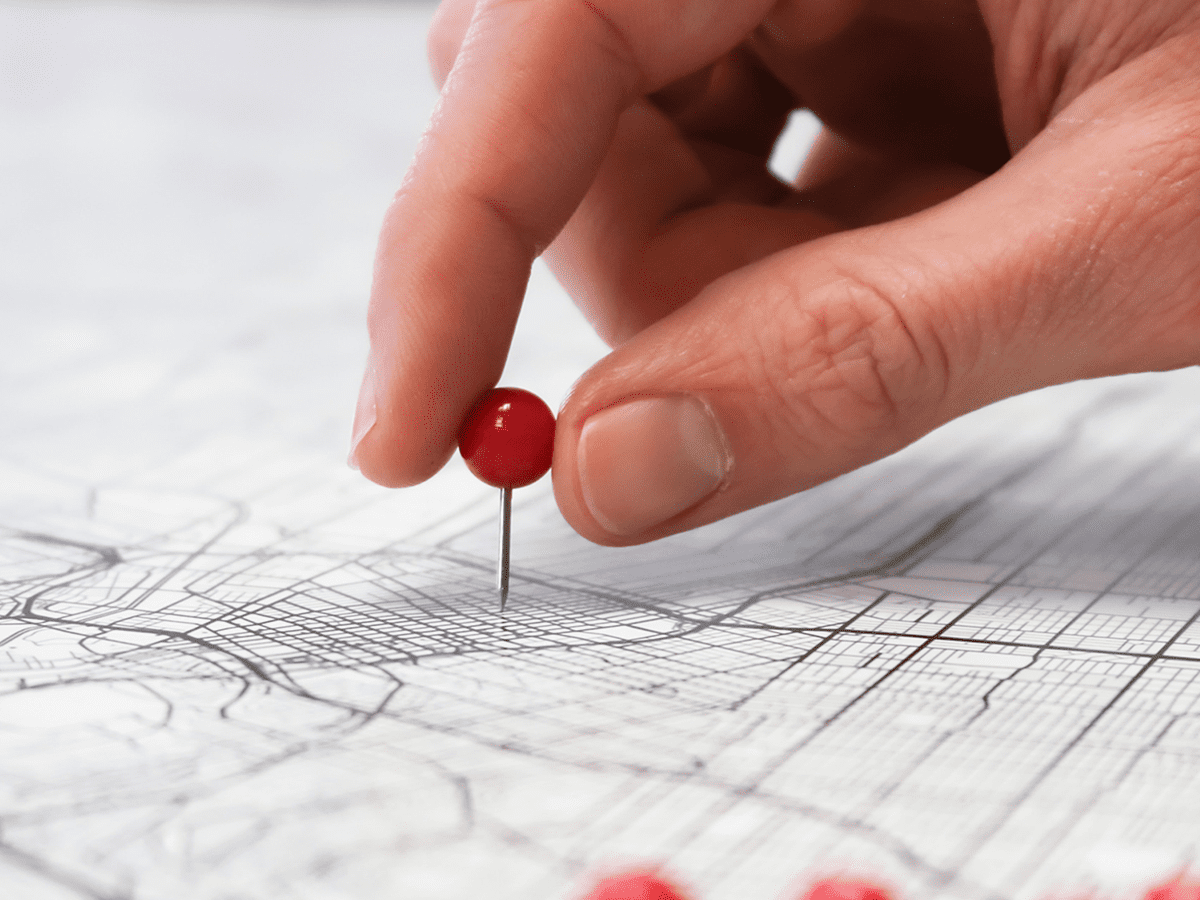 1200x900GMB-1 Person sticking a pin into a city map