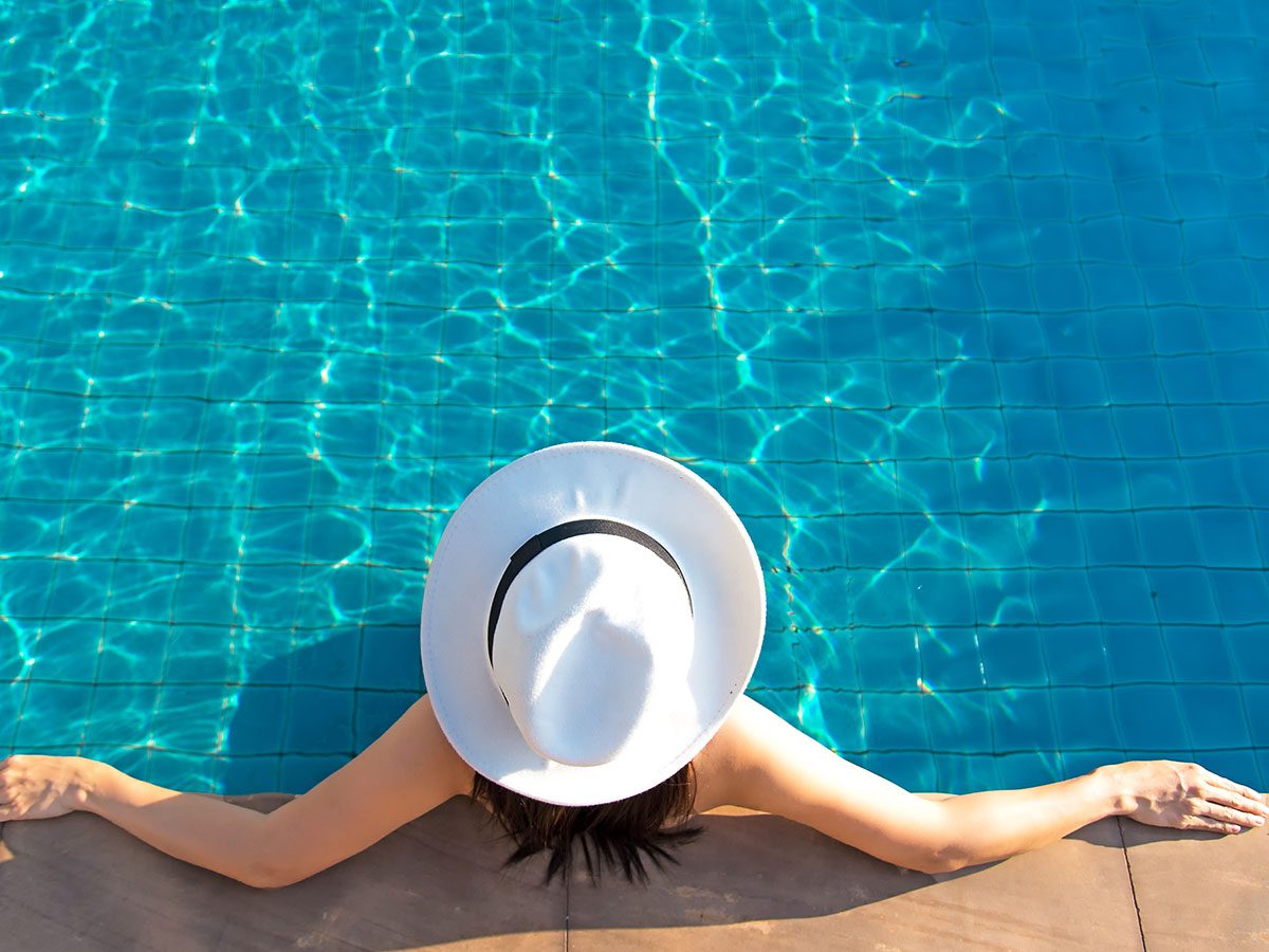 Woman in a white hat relaxing in a swimming pool
