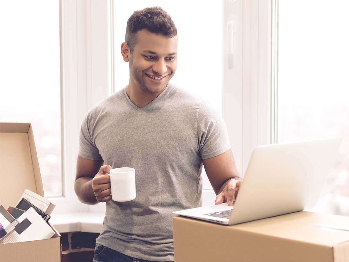 Person holding a set of keys with an apartment in the background.