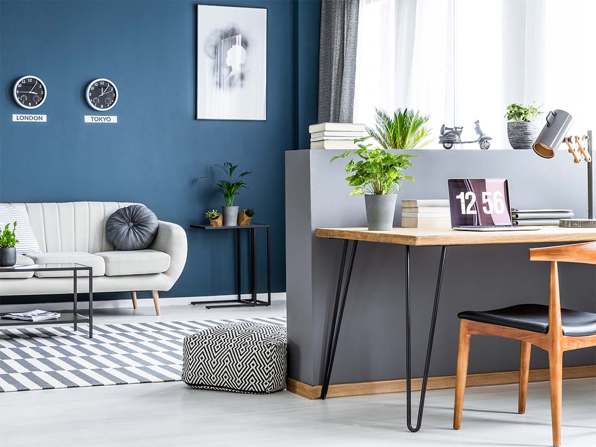 Person holding a wooden model of a home offering it to another person holding their hands out in front of them