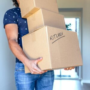 man moving kitchen boxes into apartment
