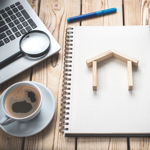 a computer and paper with a house on it