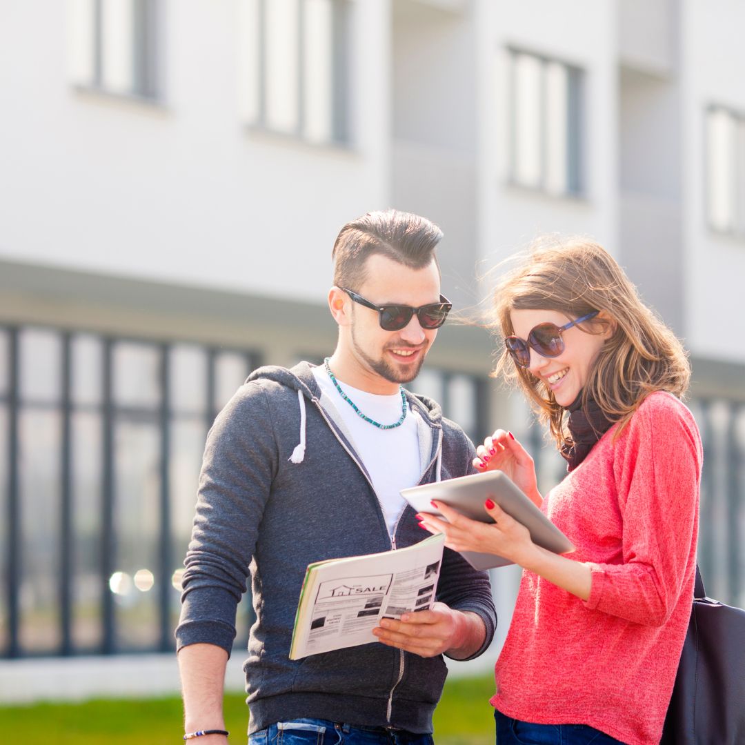 man and woman looking at tablet outside