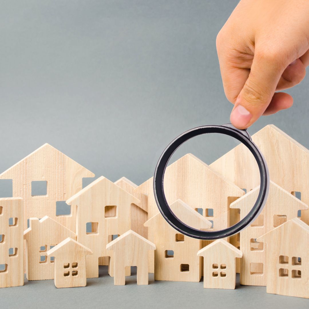 Magnifying glass over model apartments and houses