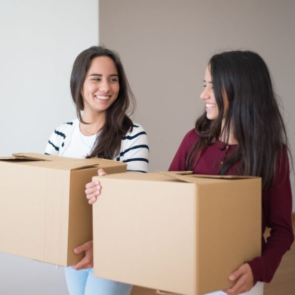 roommates carrying boxes into their new apartment